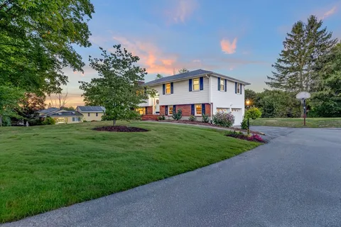 a front view of house with yard and green space