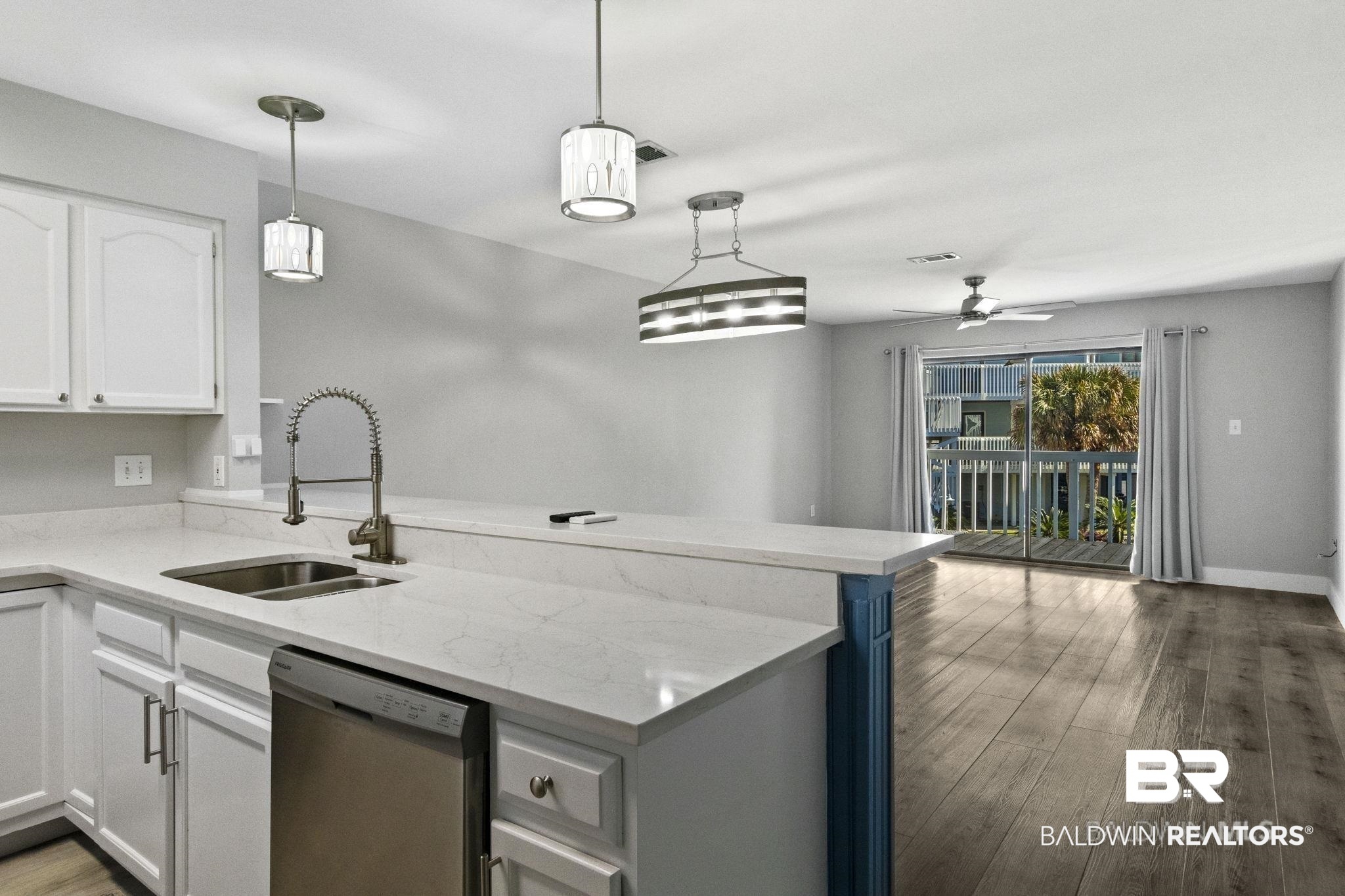 25861 Canal Road, Unit 77 Orange Beach, AL 36561 - Photo 20 of 48 Kitchen with light stone countertops, white cabinetry, dishwasher, light wood finished floors, and pendant lighting