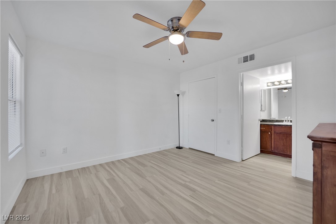 2300 East Silverado Ranch Boulevard, Unit 1189 Las Vegas, NV 89123 - Photo 19 of 27 Unfurnished bedroom featuring light wood-style floors, a ceiling fan, and ensuite bath