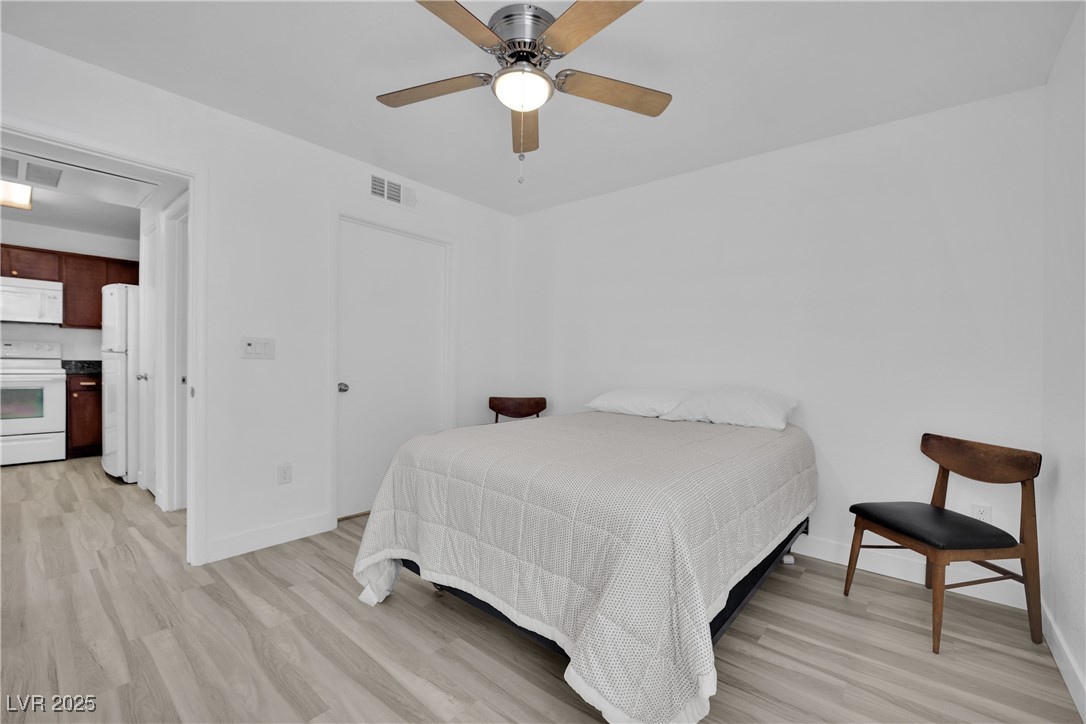 2300 East Silverado Ranch Boulevard, Unit 1189 Las Vegas, NV 89123 - Photo 22 of 27 Bedroom featuring light wood-style flooring, a ceiling fan, and freestanding refrigerator