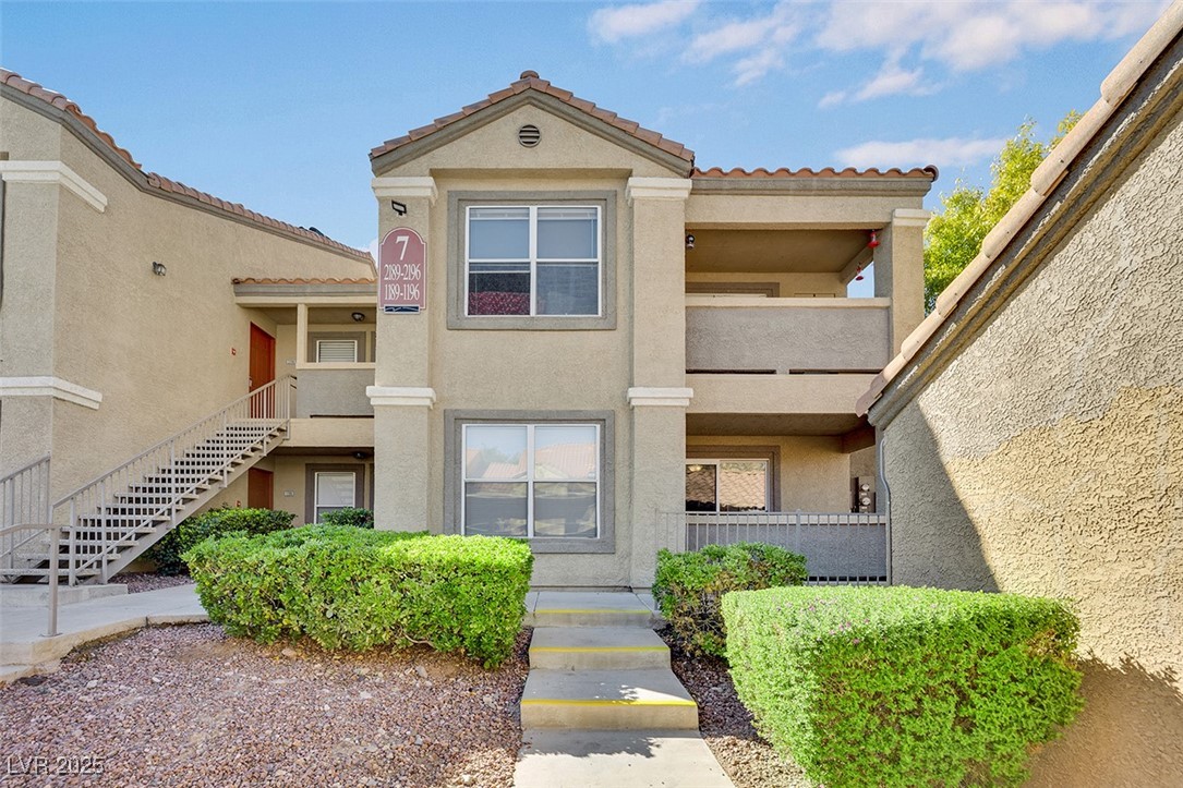 2300 East Silverado Ranch Boulevard, Unit 1189 Las Vegas, NV 89123 - Photo 27 of 27 View of front of home with stucco siding, stairway, and a balcony