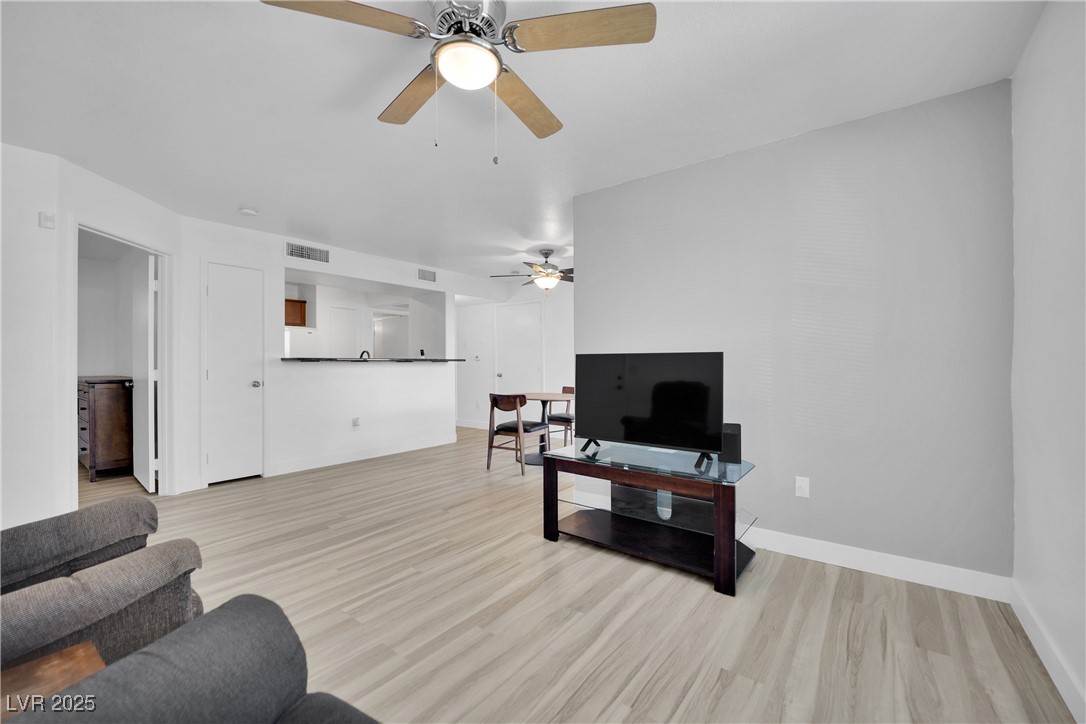 2300 East Silverado Ranch Boulevard, Unit 1189 Las Vegas, NV 89123 - Photo 6 of 27 Living area featuring light wood-style floors and ceiling fan
