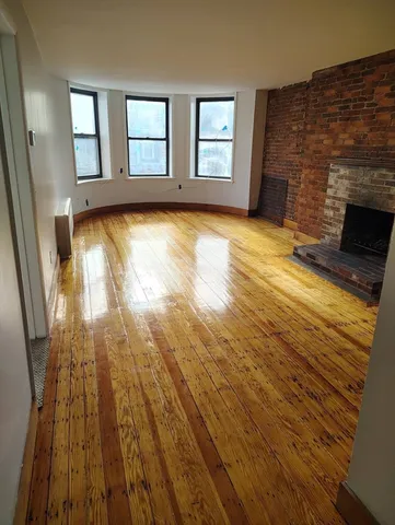 wooden floor in an empty room with a fireplace