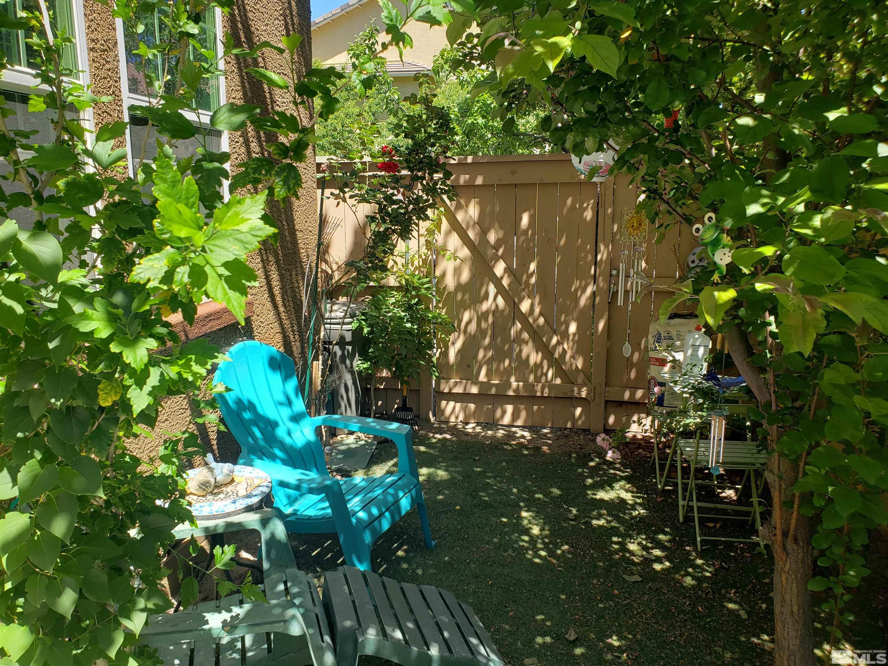 1896 Wind Ranch Road, Unit A Reno, NV 89521 - Photo 15 of 36 a backyard of a house with lots of green space and a fountain