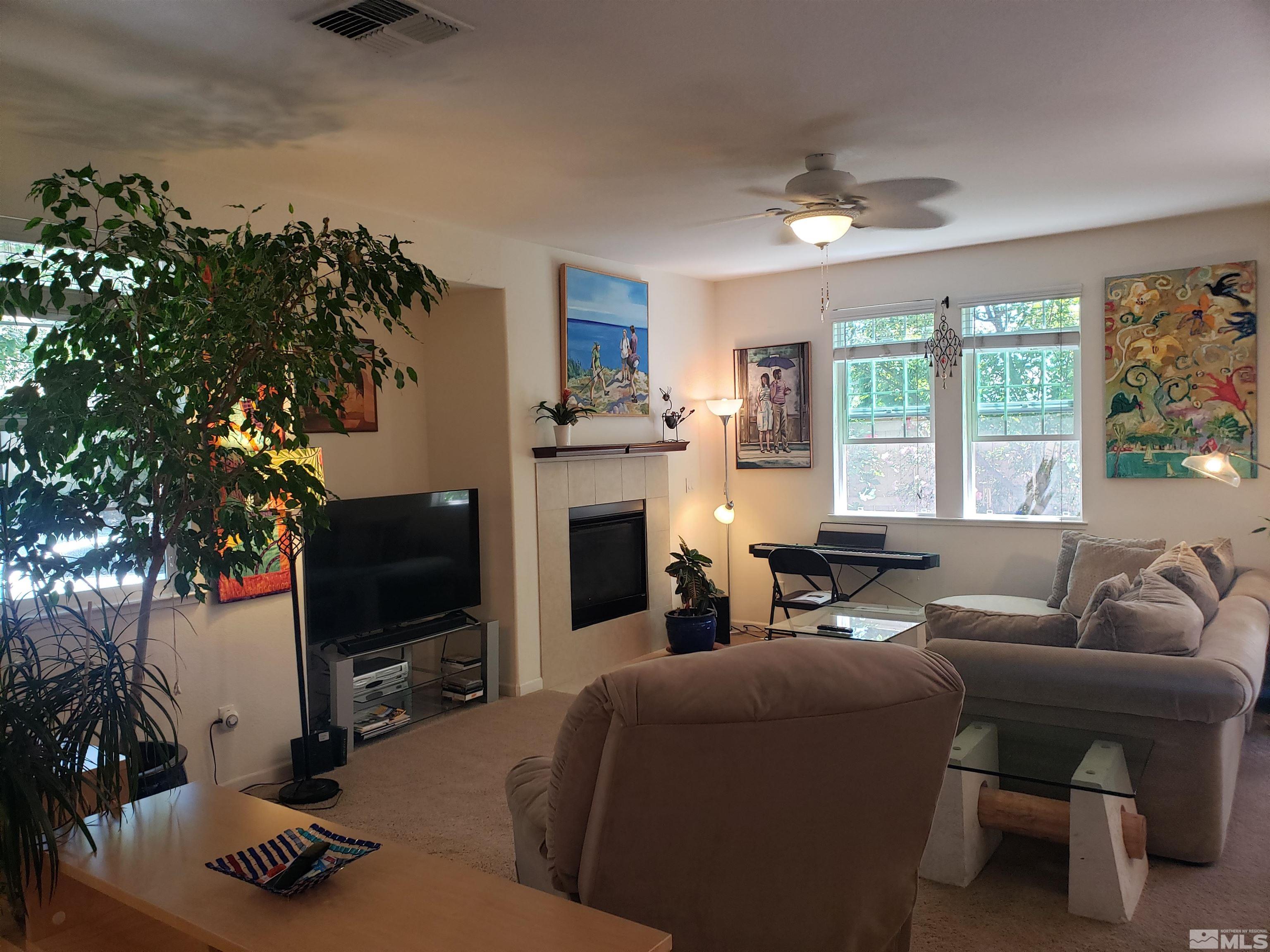 1896 Wind Ranch Road, Unit A Reno, NV 89521 - Photo 2 of 36 a living room with furniture a flat screen tv and a fireplace