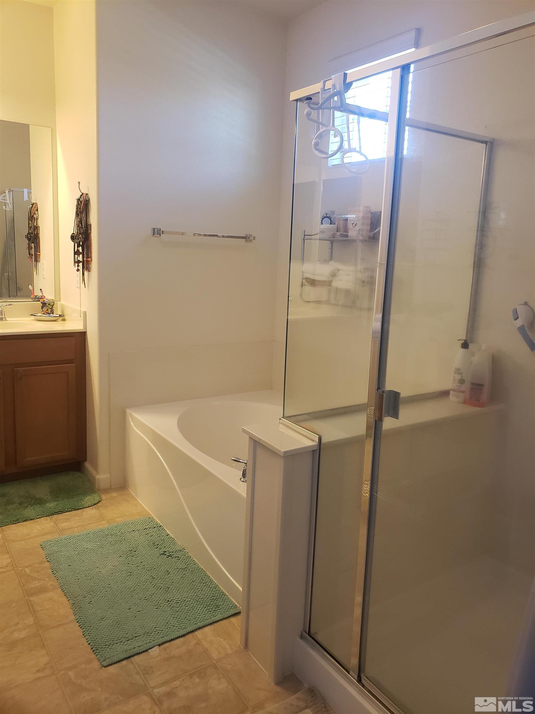 1896 Wind Ranch Road, Unit A Reno, NV 89521 - Photo 25 of 36 a bathroom with a tub shower and sink