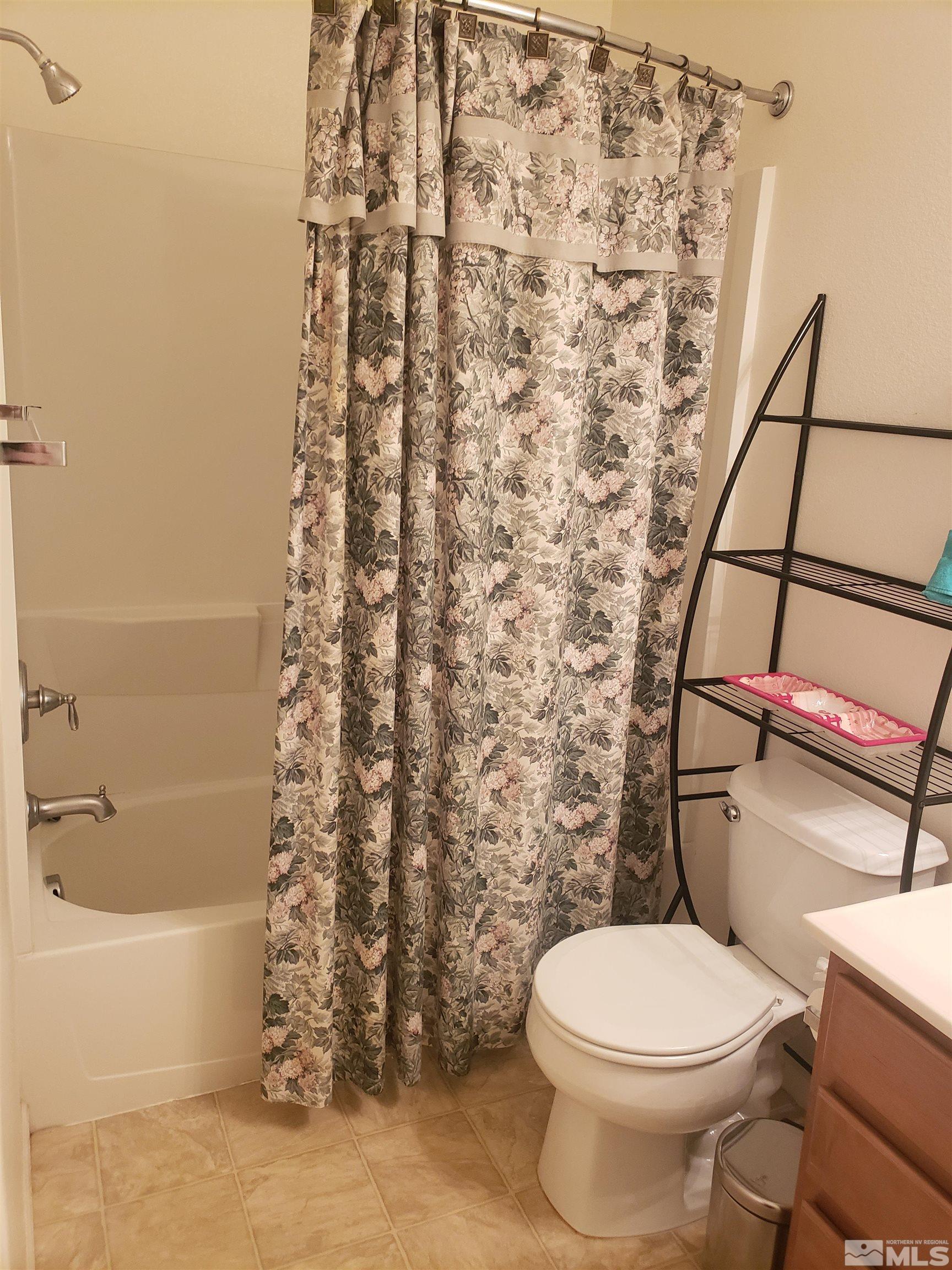 1896 Wind Ranch Road, Unit A Reno, NV 89521 - Photo 30 of 36 a white toilet sitting next to a shower curtain