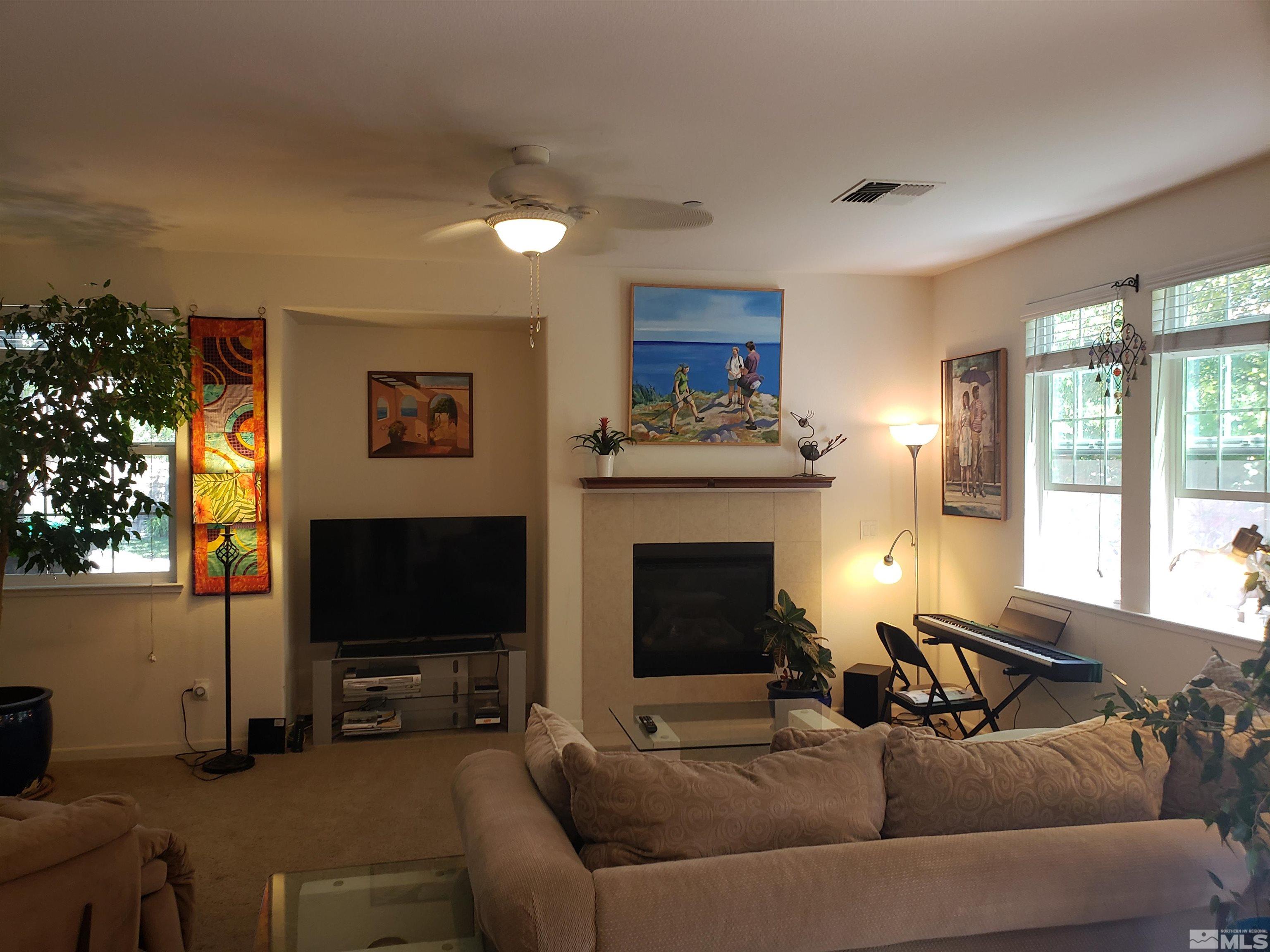 1896 Wind Ranch Road, Unit A Reno, NV 89521 - Photo 4 of 36 a living room with furniture a flat screen tv and a fireplace