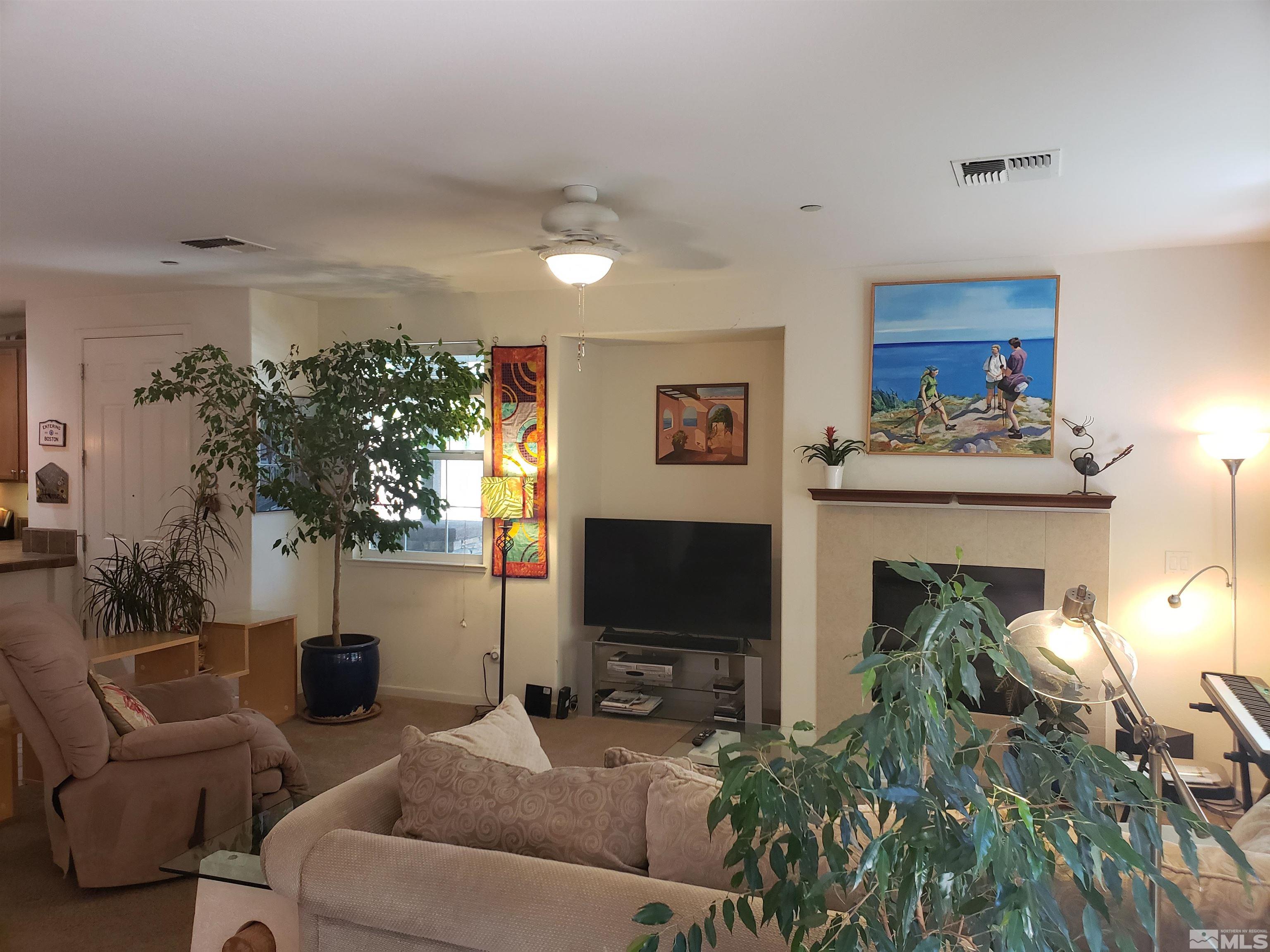 1896 Wind Ranch Road, Unit A Reno, NV 89521 - Photo 5 of 36 a living room with furniture a fireplace and a flat screen tv