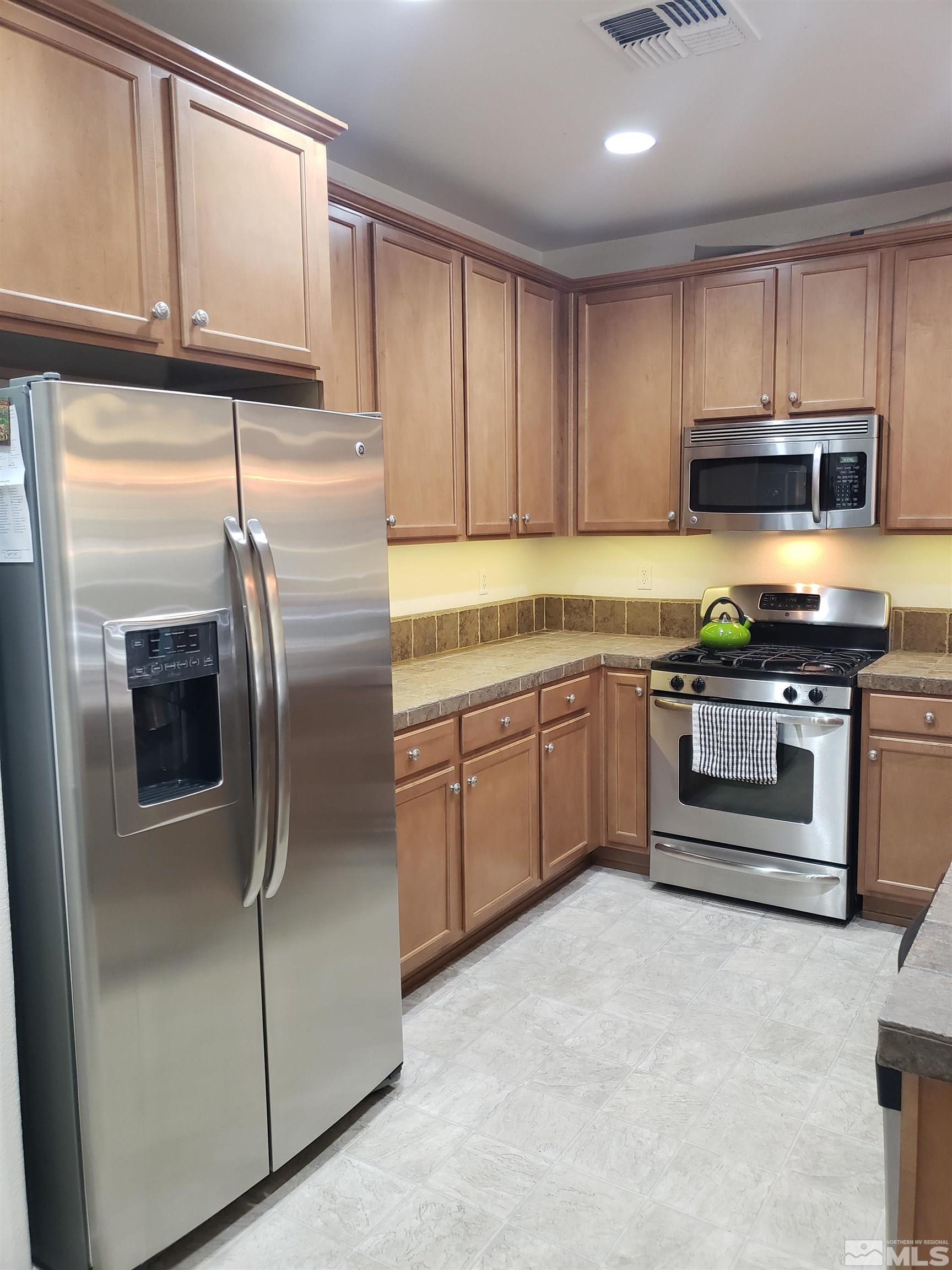 1896 Wind Ranch Road, Unit A Reno, NV 89521 - Photo 6 of 36 a kitchen with stainless steel appliances granite countertop a refrigerator a stove a sink and dishwasher