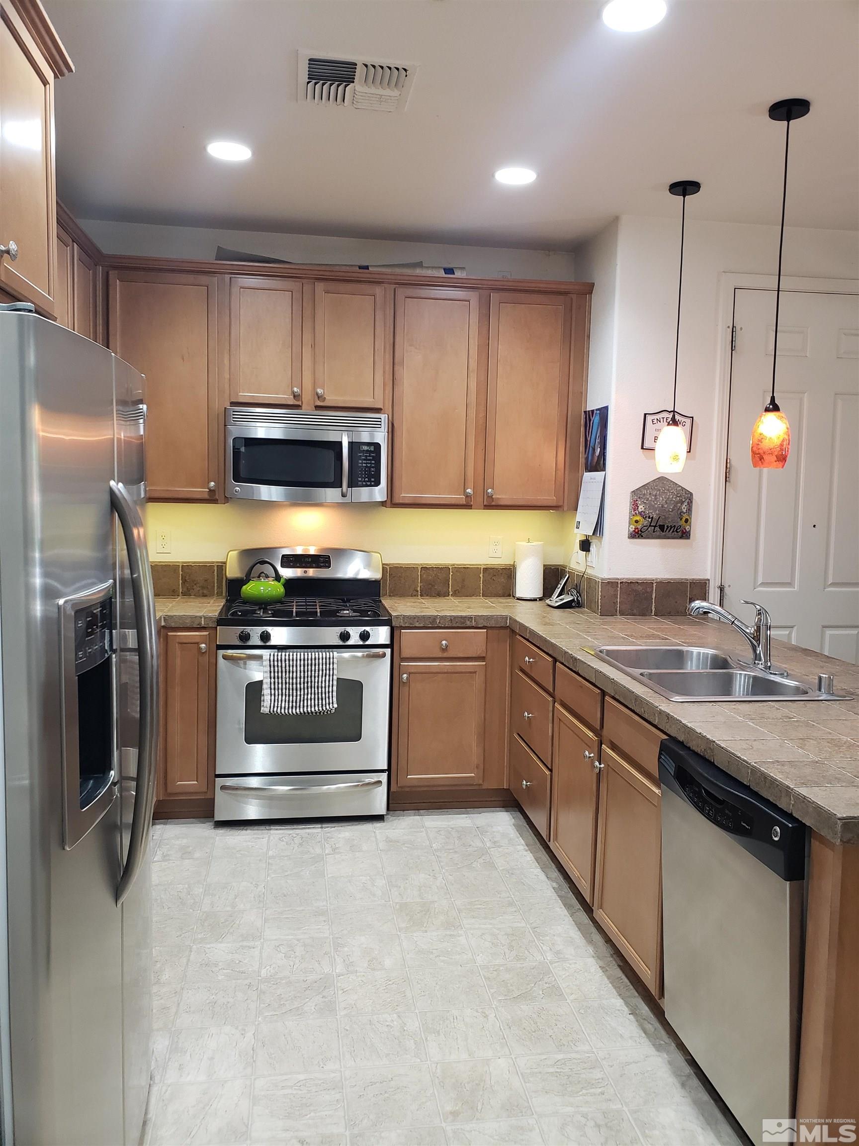 1896 Wind Ranch Road, Unit A Reno, NV 89521 - Photo 7 of 36 a kitchen with a sink stove and refrigerator