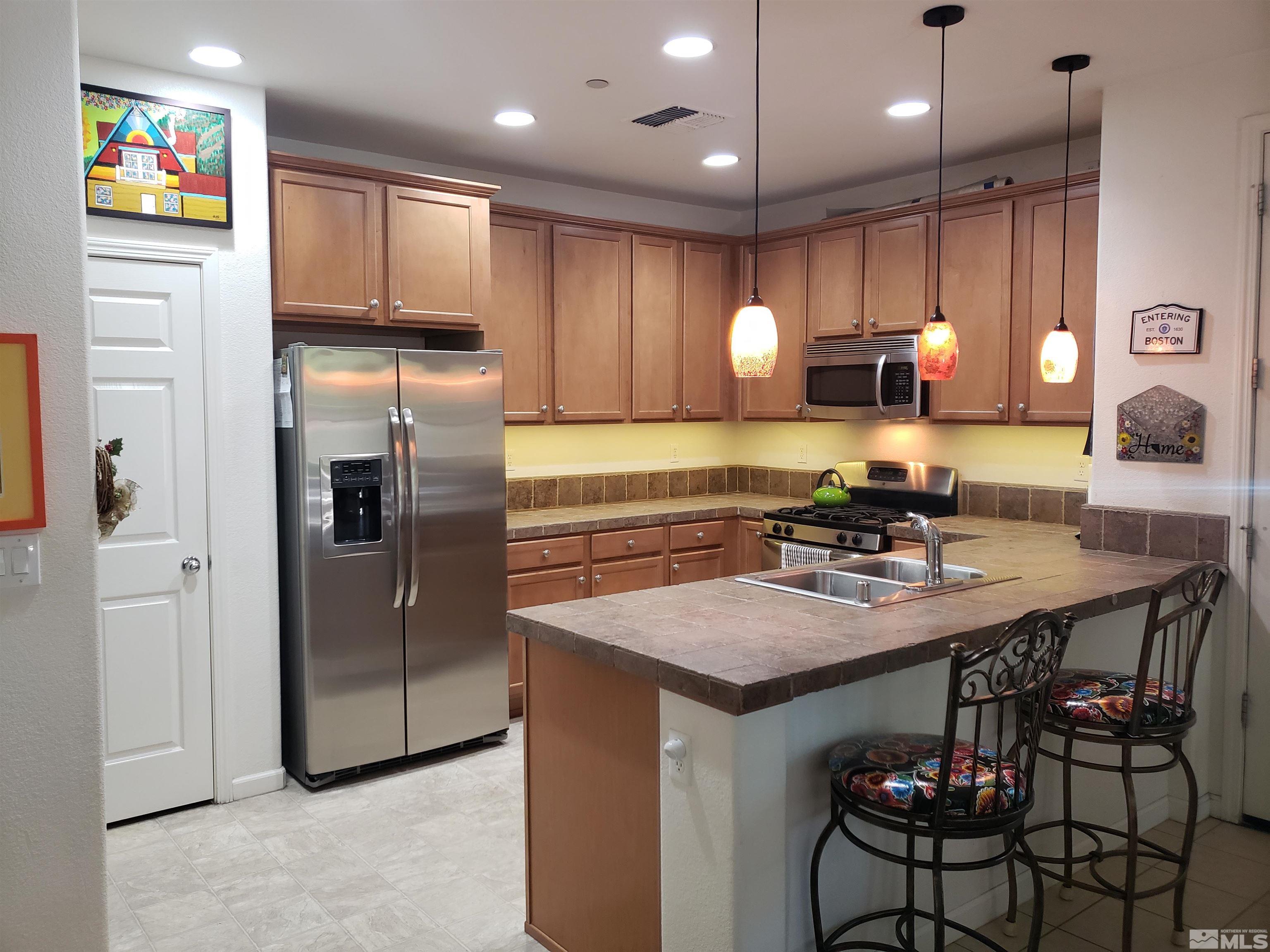 1896 Wind Ranch Road, Unit A Reno, NV 89521 - Photo 8 of 36 a kitchen with refrigerator and cabinets