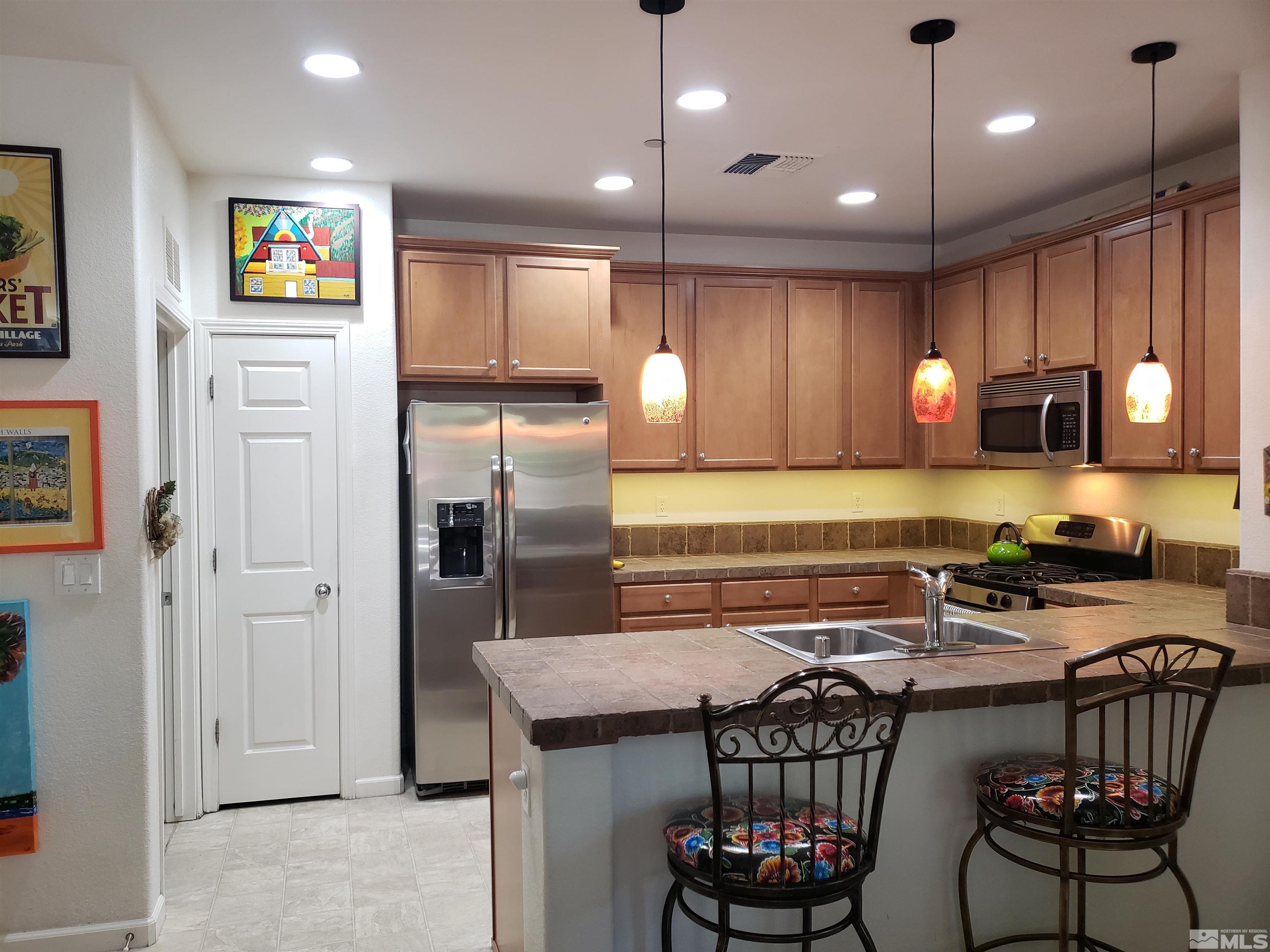 1896 Wind Ranch Road, Unit A Reno, NV 89521 - Photo 9 of 36 a kitchen with stainless steel appliances granite countertop a stove refrigerator sink and microwave