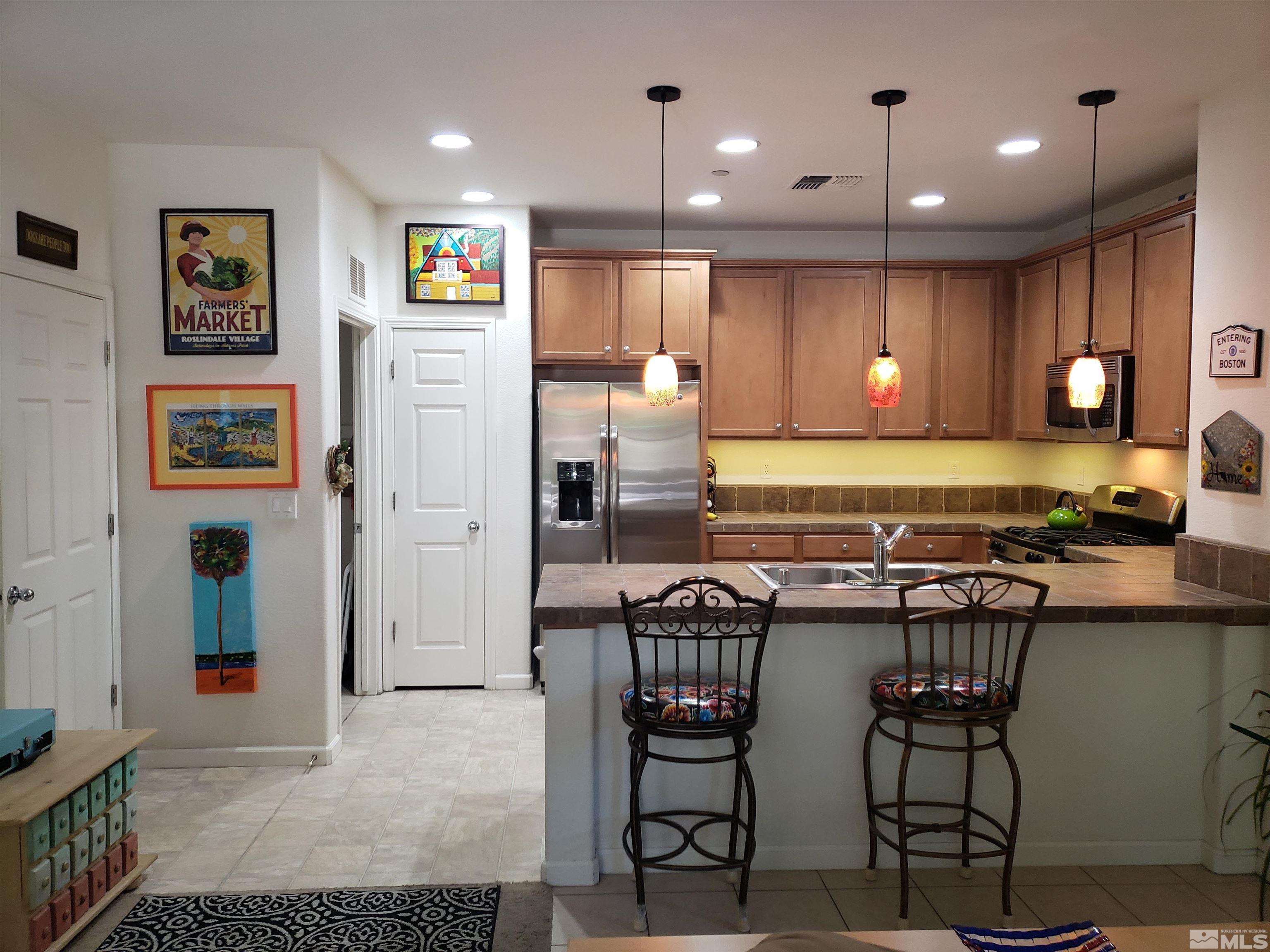 1896 Wind Ranch Road, Unit A Reno, NV 89521 - Photo 10 of 36 a kitchen with stainless steel appliances granite countertop a refrigerator and a stove top oven