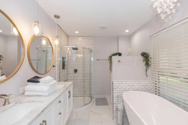 a bathroom with a granite countertop sink mirror toilet and bathtub
