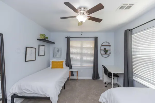 a bedroom with a bed a chair and painting on the wall