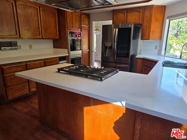 a kitchen with stainless steel appliances granite countertop a refrigerator and a stove top oven