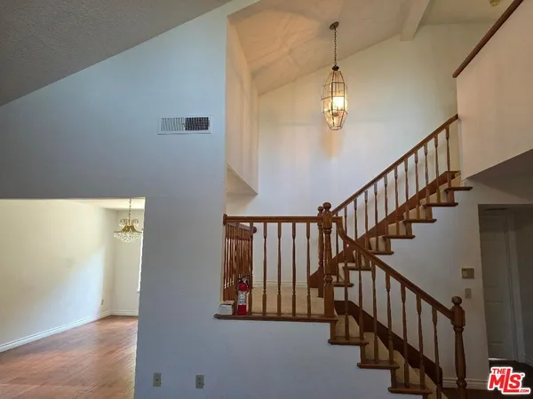 a view of staircase with railing and a chandelier