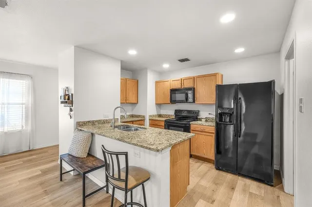 a kitchen with stainless steel appliances granite countertop a stove refrigerator and cabinets