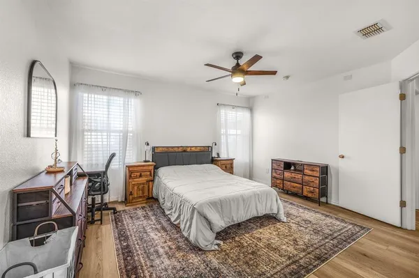 a bedroom with a bed a chair and a chandelier
