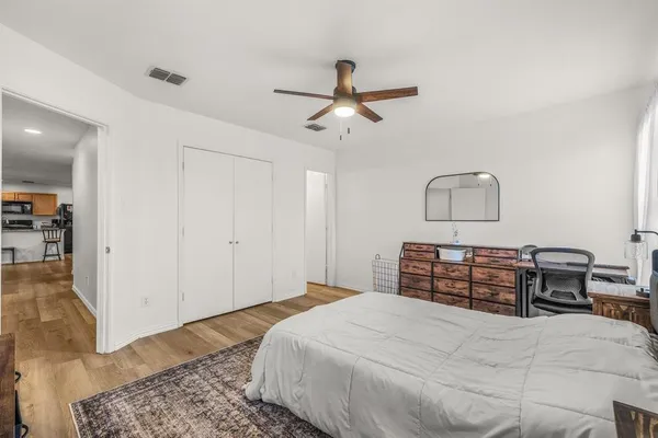 a bedroom with a large bed and wooden floor