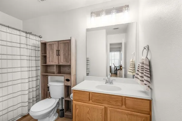 a bathroom with a sink toilet vanity and shower