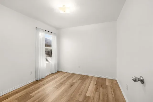 a view of a room with wooden floor and a window