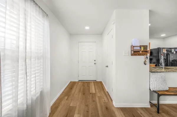 a view of a hallway with wooden floor and staircase