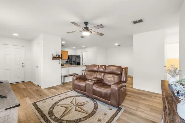 a living room with furniture and a wooden floor