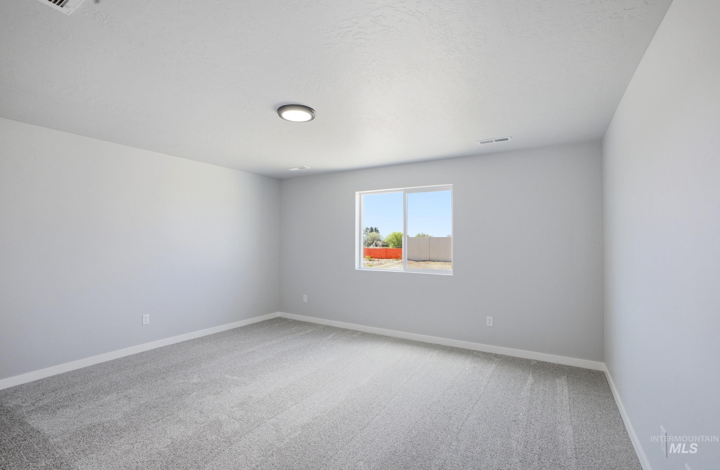 14106 Winding Street Caldwell, ID 83607 - Photo 15 of 18 Spacious interior room featuring light gray carpeting, white baseboards, and a single window providing natural illumination