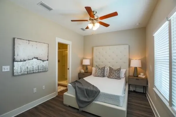 a bedroom with a large bed and a chandelier