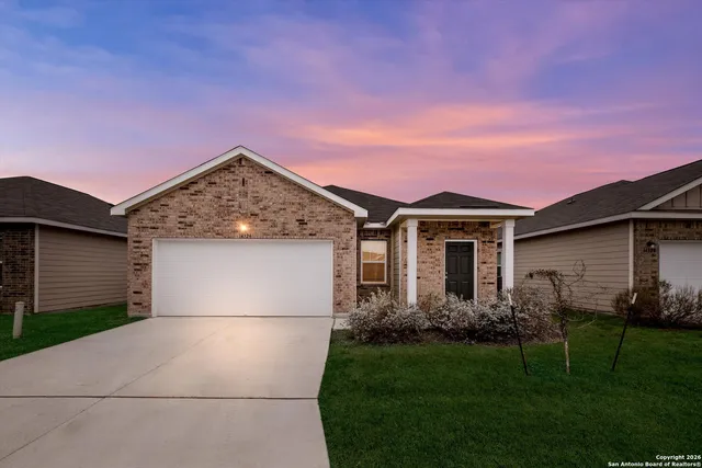 a front view of a house with a garden and yard