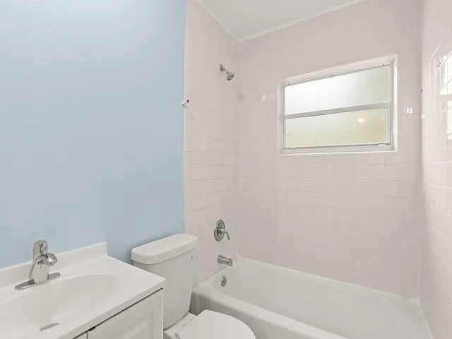 a white bath tub sitting next to a white sink and a toilet