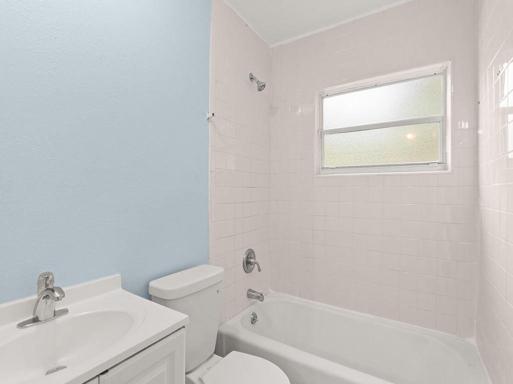 4341 35th Avenue Vero Beach, FL 32967 - Photo 15 of 25 a white bath tub sitting next to a white sink and a toilet