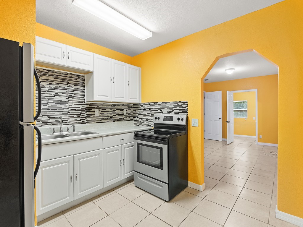 4341 35th Avenue Vero Beach, FL 32967 - Photo 9 of 25 a kitchen with stainless steel appliances granite countertop a sink and cabinets