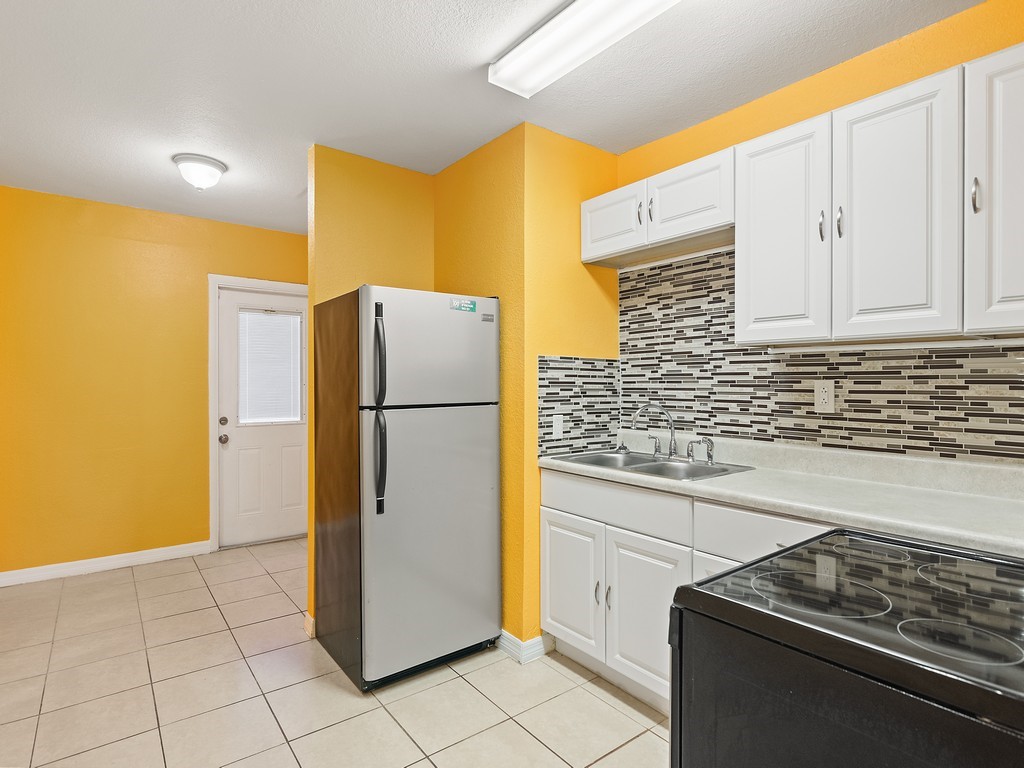 4341 35th Avenue Vero Beach, FL 32967 - Photo 10 of 25 a kitchen with a refrigerator sink and cabinets