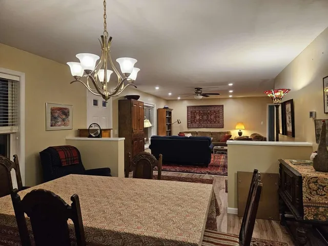 a living room with furniture a chandelier and a flat screen tv