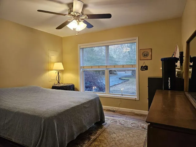 a bedroom with a bed dresser and a window