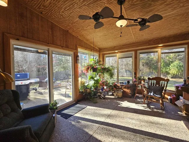 a living room with patio furniture and a floor to ceiling window