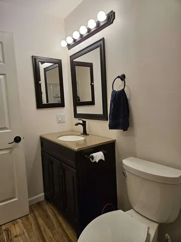 a bathroom with a toilet sink and mirror