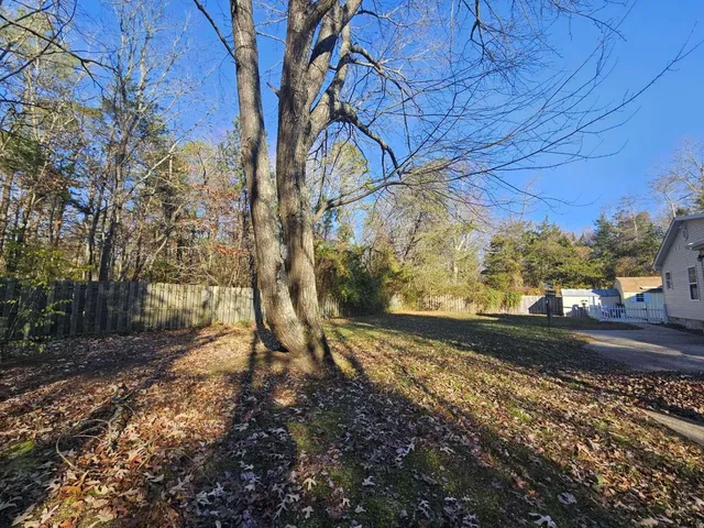 a view of a yard with wooden fence
