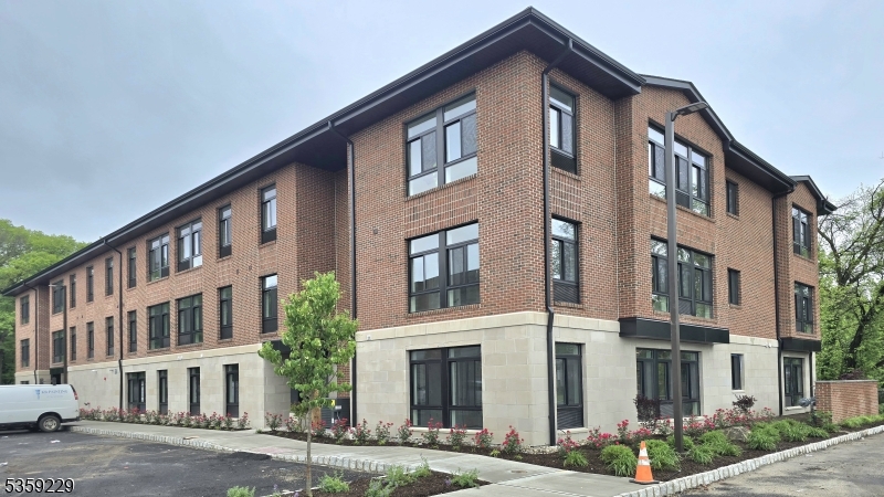 135 Fairfield Road, Unit 205 Fairfield, NJ 07004 - Photo 1 of 18 a front view of a building with a yard
