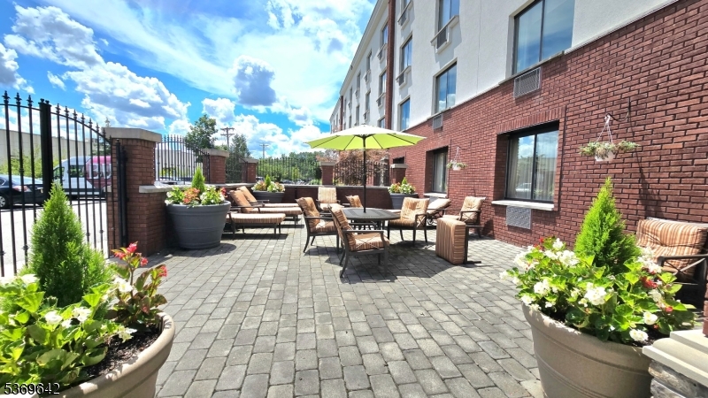135 Fairfield Road, Unit 205 Fairfield, NJ 07004 - Photo 18 of 18 a view of a patio with dining table and chairs potted plants