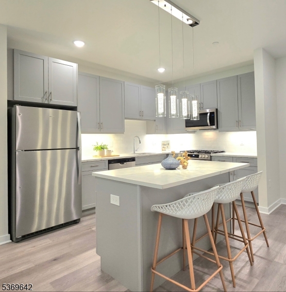 135 Fairfield Road, Unit 205 Fairfield, NJ 07004 - Photo 5 of 18 a kitchen with stainless steel appliances granite countertop a refrigerator a stove a sink dishwasher and a refrigerator with wooden floor