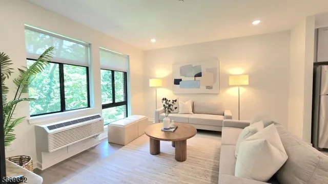 a living room with furniture and a large window with wooden floor