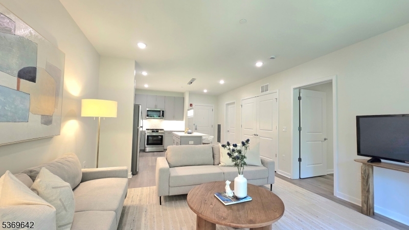 135 Fairfield Road, Unit 205 Fairfield, NJ 07004 - Photo 7 of 18 a living room with furniture and a flat screen tv