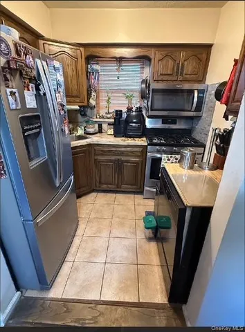 a kitchen with stainless steel appliances a stove a refrigerator a sink and a counter