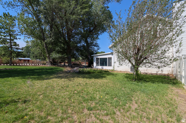 270 East 100 North Monroe, UT 84754 - Photo 40 of 65 Expansive green lawn area featuring mature trees and a screened-in porch with white siding