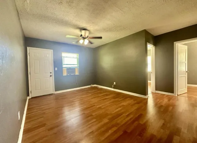 a view of empty room with wooden floor