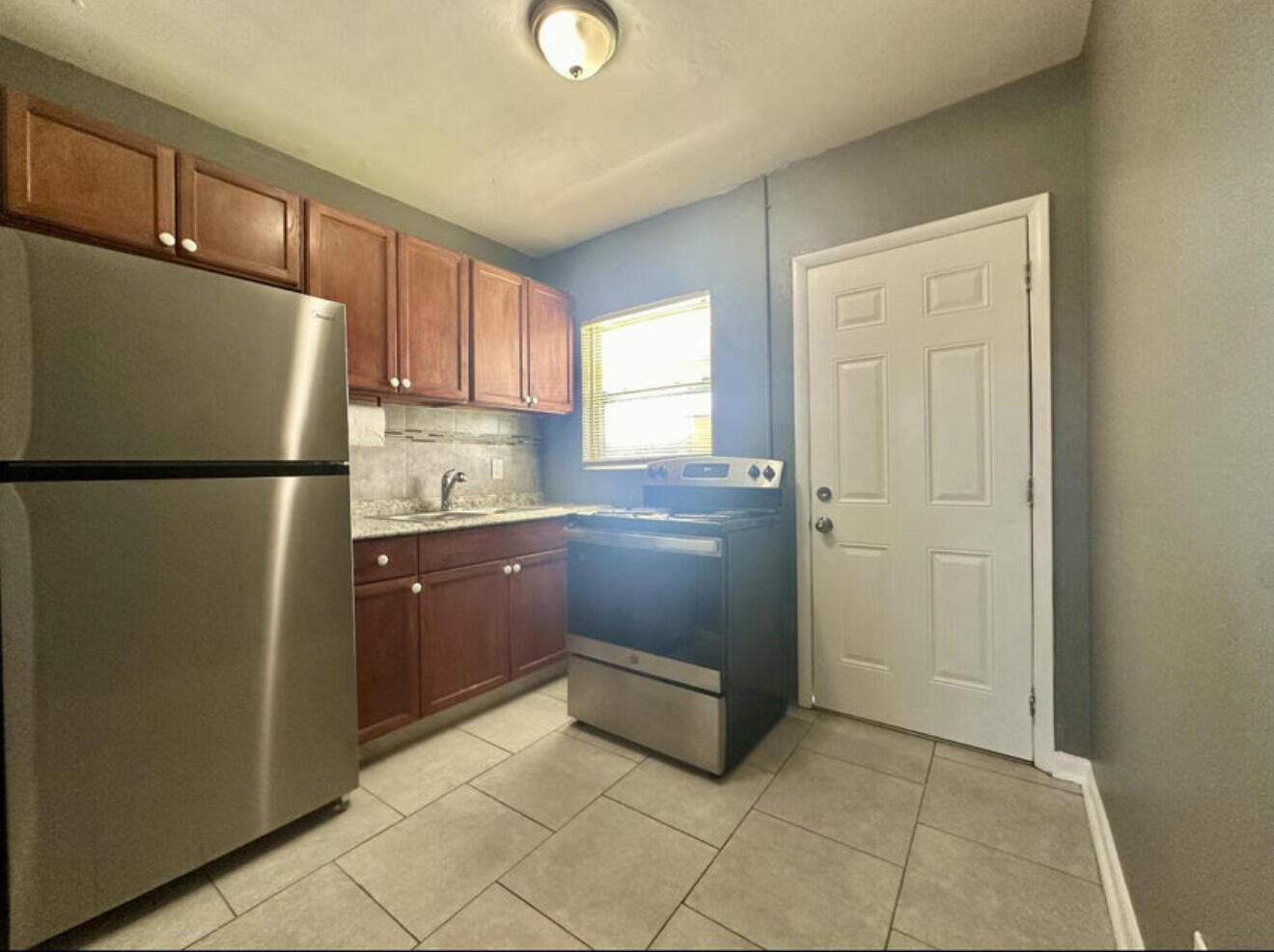 24 Southwest 10th Avenue Delray Beach, FL 33444 - Photo 8 of 25 a kitchen with a refrigerator sink and cabinets